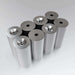 A collection of nickel-plated countersunk neodymium magnets with a hole in the center, arranged in stacks.
