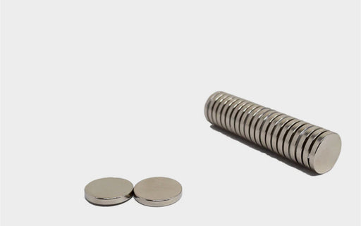 Diameter 10mm x thickness 1mm N35 neodymium round disc magnets stacked in a row and two magnets are front left of the image