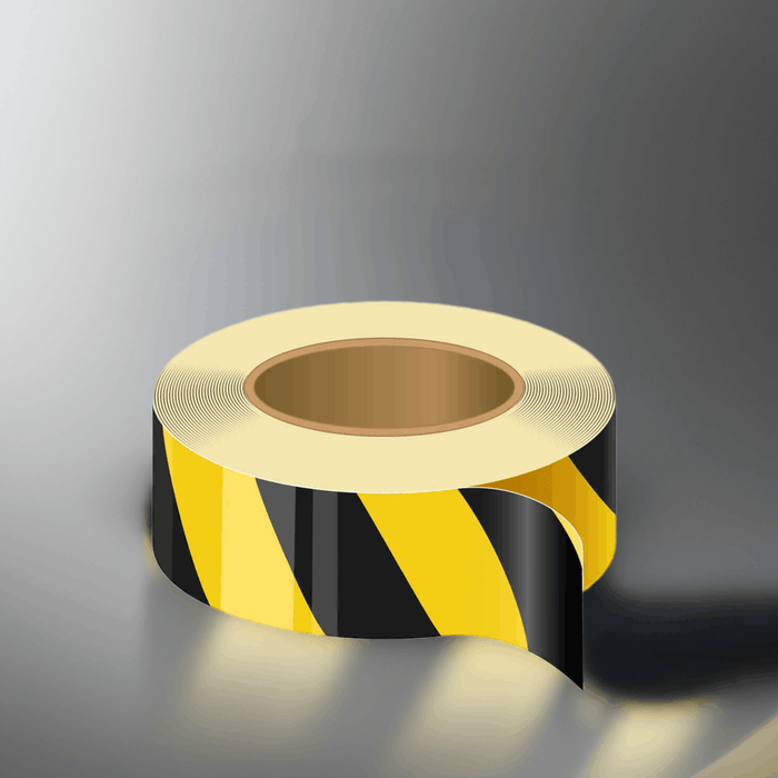 Roll of black and yellow striped tape on a gray background